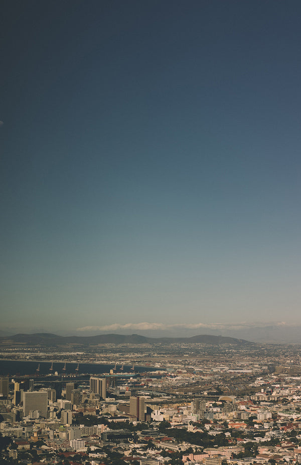 Cityscape with port in the middle dostance and a cloudless sky.