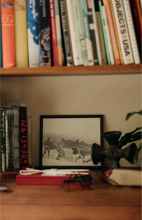 A vintage photograph of surfers on a bookshelf
