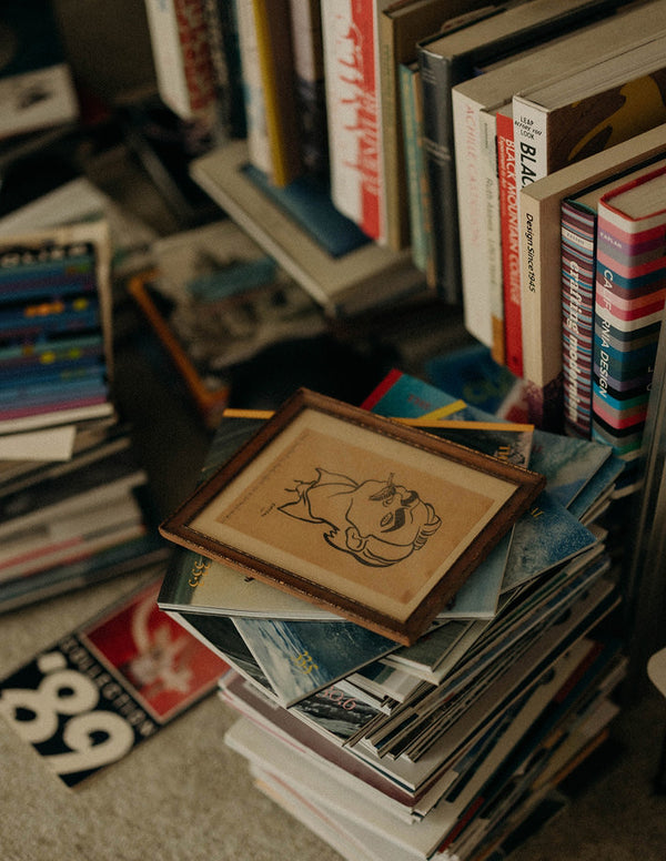 A framed art print atop a stack of books