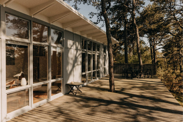 Glass windows and a wooden deck at the Lechay House