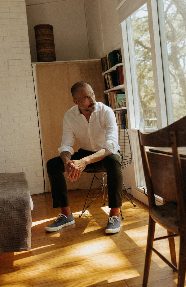 Model sitting on a metal chair in the Lechay House