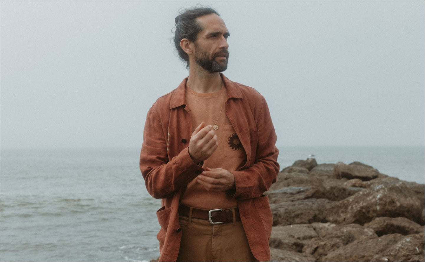 Daren standing by the sea in The Embroidered Ojai and The Heavy Bag Tee