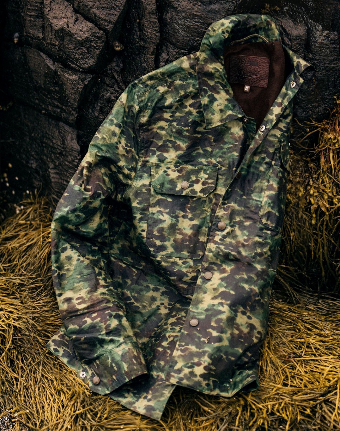 The Venture Jacket in Painted Camo Waxed Canvas on the ground
