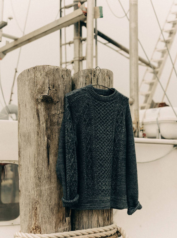 The Orr Sweater in Marled Marine Merino, hanging on a piling
