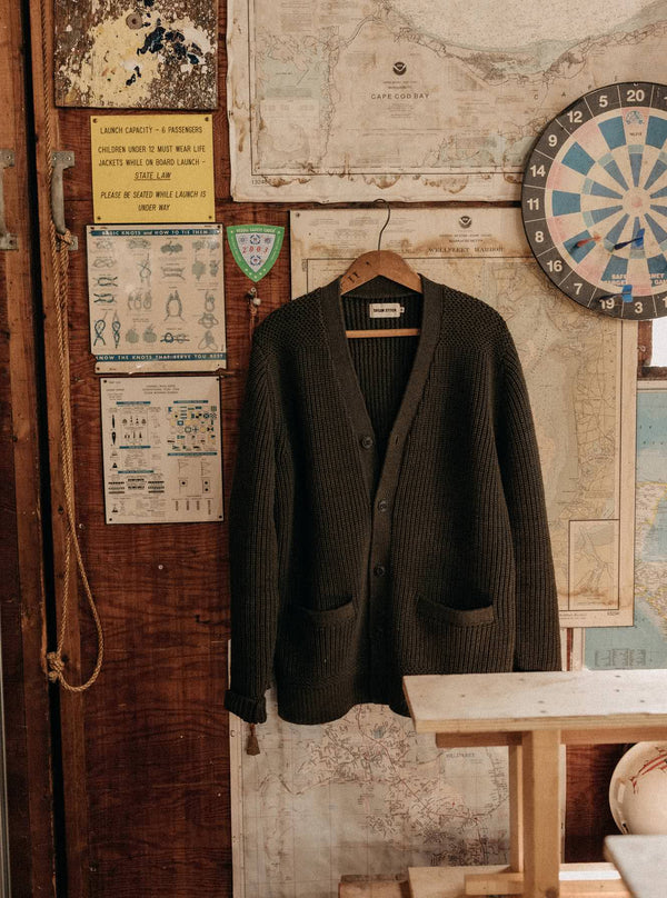 The Mariner Cardigan in Heather Loden Slub hanging on a wall